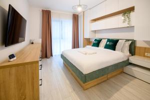 a bedroom with a large bed and a television at Smart Concept Living Plaza in Bucharest