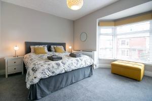una camera con un grande letto e uno sgabello giallo di Host & Stay - Saltburn Sea House a Saltburn-by-the-Sea