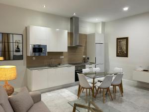 a kitchen and dining room with a table and chairs at Olavide Premium Apartments in Seville