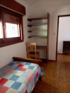 1 dormitorio con 1 cama, 1 silla y 1 ventana en Vistas de Embalsina en Villa del Dique