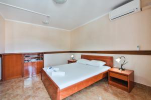 um quarto com uma grande cama branca num quarto em Garni Hotel Koral em Budva