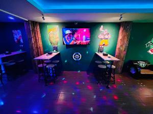 a bar with two tables and a tv on the wall at Popeyes Hostel, Coffeeshop & Beer Bar in Patong Beach