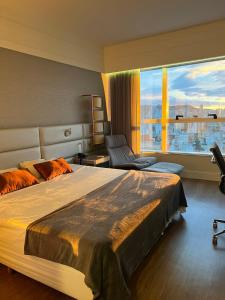 1 dormitorio con cama grande y ventana grande en BH PARA 2 - HOTEL LUXO Apartamento Particular Savassi, en Belo Horizonte
