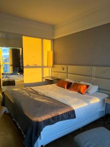 1 dormitorio con 1 cama grande con almohadas de color naranja en BH PARA 2 - HOTEL LUXO Apartamento Particular Savassi, en Belo Horizonte