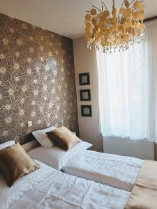 a bedroom with two beds and a chandelier at Silver Lodge Apartment 1 Eger in Eger
