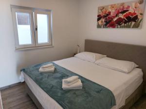 een slaapkamer met een bed met twee handdoeken erop bij VILLA ENJOY LUX private heated pool in Split in Split