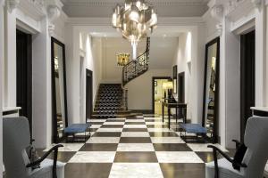 a hallway with a checkerboard floor and a chandelier at Hôtel Mont-Blanc Chamonix in Chamonix