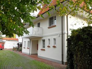 Casa blanca con balcón y patio en Mücke, Christian, en Zingst