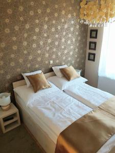 two twin beds in a bedroom with a wall at Silver Lodge Apartment 1 Eger in Eger