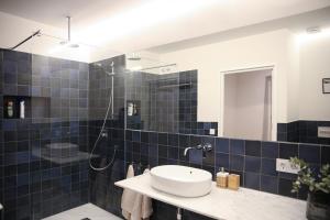 a blue tiled bathroom with a sink and a shower at Casa Arcadia in Córdoba +24 photos
