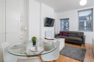 a living room with a glass table and a couch at Soho & Covent Garden Apartment, Sleeps 3 in London