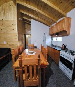 cocina con mesa de madera y fogones en Cabaña Itu en Ituzaingó