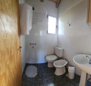 y baño con aseo y lavamanos. en Cabaña Itu en Ituzaingó