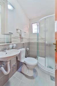 Garni Hotel Koral في بودفا: حمام مع مرحاض ومغسلة ودش