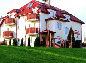 a large white building with a red roof at Rades in Władysławowo