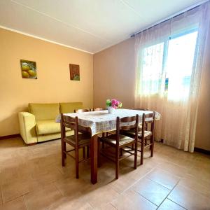 een eetkamer met een tafel en stoelen en een bank bij Residence il Faro in Marina di Monasterace