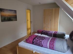 a bedroom with a bed with purple pillows on it at Ferienwohnung in Scharnebeck in Scharnebeck +5 photos