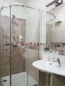 ein Bad mit einer Dusche und einem Waschbecken in der Unterkunft Silver Lodge Apartment 1 Eger in Eger