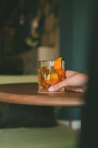 a person holding a glass of tea on a table at Kimpton Aysla Mallorca by IHG in Santa Ponsa