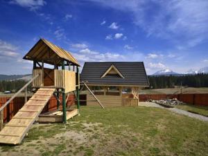 una pequeña casa con un tobogán y un parque infantil en Willa U Góralki en Murzasichle