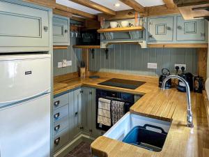 a kitchen with blue cabinets and a sink at Johnsons Cottage - Uk39727 in Taddington