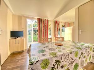 a bedroom with a bed and a tv and a window at Résidence Les Pavillons du Golfe in Favone