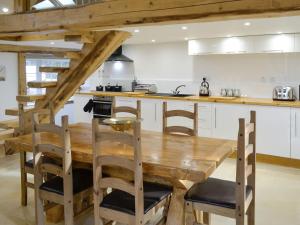 a kitchen with a wooden table and some chairs at Coombe View in South Redworthy