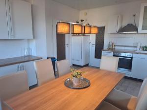 cocina con mesa de madera con sillas y comedor en Ferienwohnung Großdobritz, en Niederau