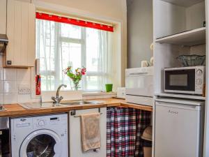 une cuisine avec un lave-linge et un sèche-linge sur un comptoir dans l'établissement Kirk Wynd Cottage, à Kirriemuir