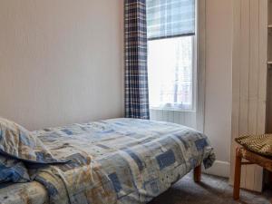 a bedroom with a bed and a window at Kirk Wynd Cottage in Kirriemuir