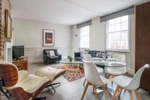 een woonkamer met een tafel en stoelen bij Trendy Apartment in Central Soho - Piccadilly in Londen