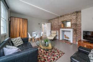uma sala de estar com um sofá e uma parede de tijolos em Trendy Apartment in Central Soho - Piccadilly em Londres