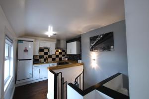 een keuken met witte kasten en een trap in een kamer bij Royal Manor Park in Llandudno