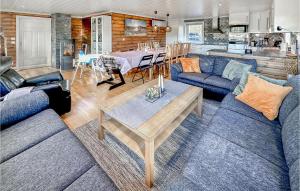 una sala de estar con sofás azules y una mesa. en Awesome Home In Mykland With Kitchen, en Mykland