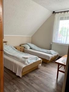 a bedroom with two beds and a window at Attila Vendégház in Kiskunmajsa