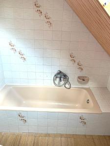 a bath tub with a faucet in a bathroom at Attila Vendégház in Kiskunmajsa