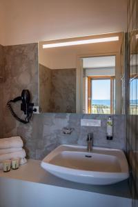 a bathroom with a sink and a mirror at Hôtel l'Albatros in Damgan