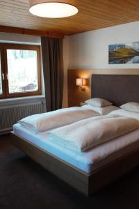 Un dormitorio con una cama grande y una ventana en Haus Biberkopf, en Lech am Arlberg