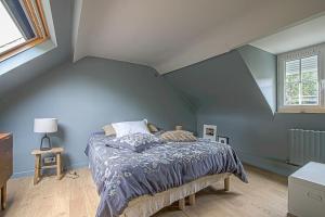 Maison de ville avec jardin Etretat في إتريتا: غرفة نوم بسرير مع جدار ازرق