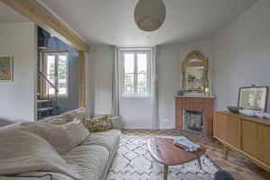 a living room with a couch and a fireplace at Maison de ville avec jardin Etretat in Étretat