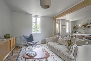 a living room with a couch and a table at Maison de ville avec jardin Etretat in Étretat