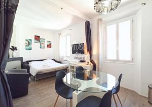 ein Wohnzimmer mit einem Glastisch und einem Sofa in der Unterkunft Viva Riviera - 10 Rue Florian in Cannes