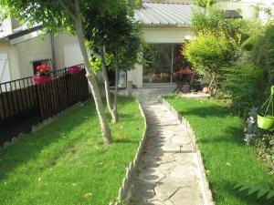 a garden with a stone path in front of a house at Le Grand Paris - Entre Paris et Disneyland Paris in Champigny-sur-Marne