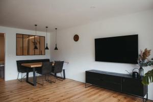 a dining room with a table and a tv on a wall at Schwarzwald Loft Menzenschwand in Menzenschwand