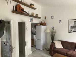 a living room with a couch and a refrigerator at Le Grand Paris - Entre Paris et Disneyland Paris in Champigny-sur-Marne