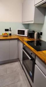 a kitchen with white cabinets and a stove top oven at Lovely 2 bedroom Flat with Free Parking in New Southgate