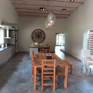 cocina y comedor con mesa de madera y sillas en CASA LOS CASTAÑOS en Tafí del Valle