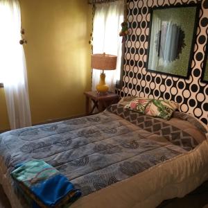 1 dormitorio con 1 cama grande y espejo en la pared en CASA LOS CASTAÑOS en Tafí del Valle