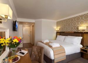 a hotel room with a bed and a table with flowers at Limerick City Hotel in Limerick