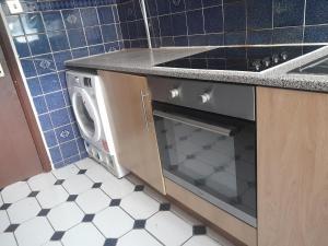 a kitchen with a stove and a dishwasher at Lovely 1-Bed Studio in London in London